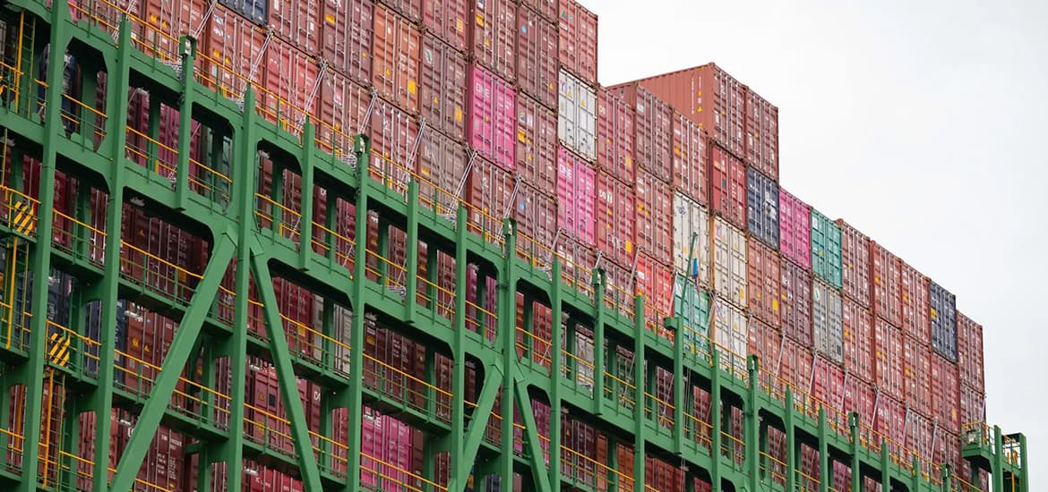Multicolored shipping containers stacked on a cargo vessel, representing global shipping and international trade.