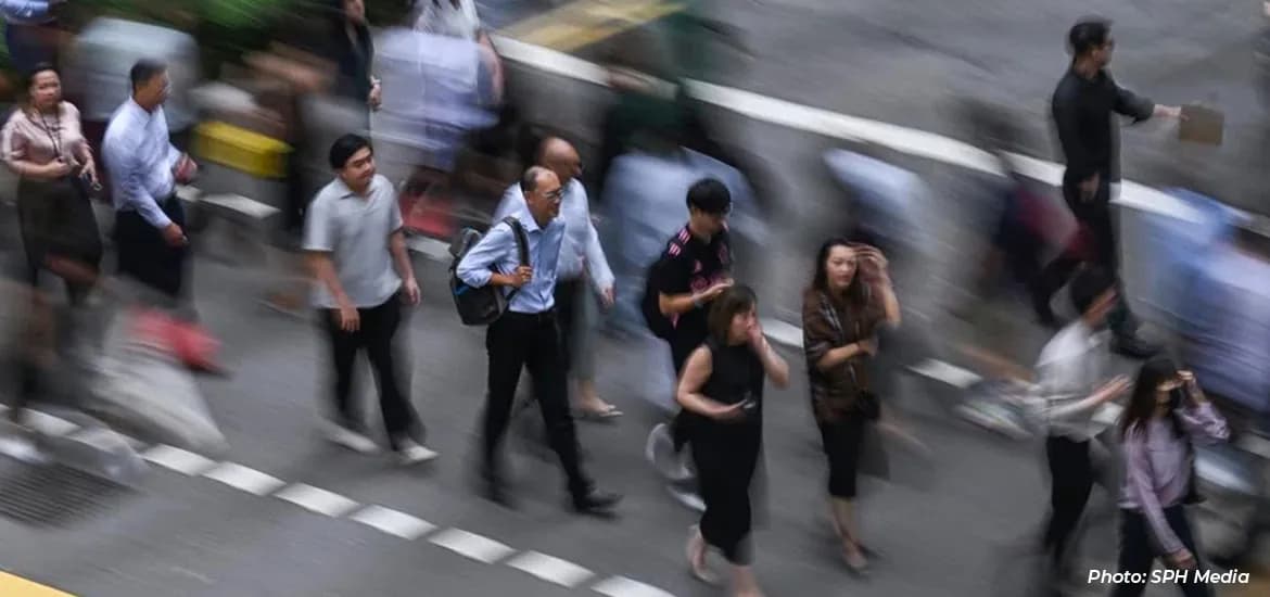 Blurred motion view of people walking across a busy street crossing in a city.