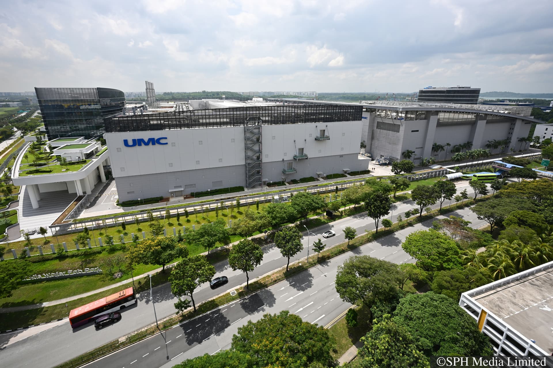 ST20250401-202567400139-Lim Yaohui-Sheila Chiang-scumc01/Exterior facade of UMC’s new advanced fab expansion (left with logo) and current fab facility (right) in Singapore during its grand opening on April 1, 2025. This milestone represents a major leap in semiconductor manufacturing, strengthening Singapore’s position as a global tech and innovation hub while creating high-value local job opportunities.With this launch, UMC’s Singapore site will become one of the most advanced semiconductor fabs in the country, further cementing its role in driving cutting-edge advancements and reinforcing Singapore’s leadership in the global supply chain.(ST PHOTO: LIM YAOHUI)