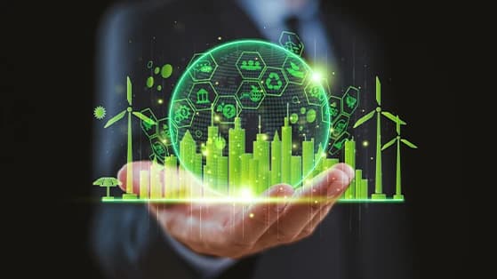 Hand holding a glowing digital globe with green energy icons