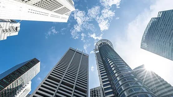 Low-angle view of Singapore skyscrapers against the sky.