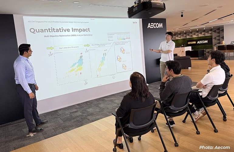 AECOM team members presenting and discussing data visualisations during a meeting in a modern office presentation space.