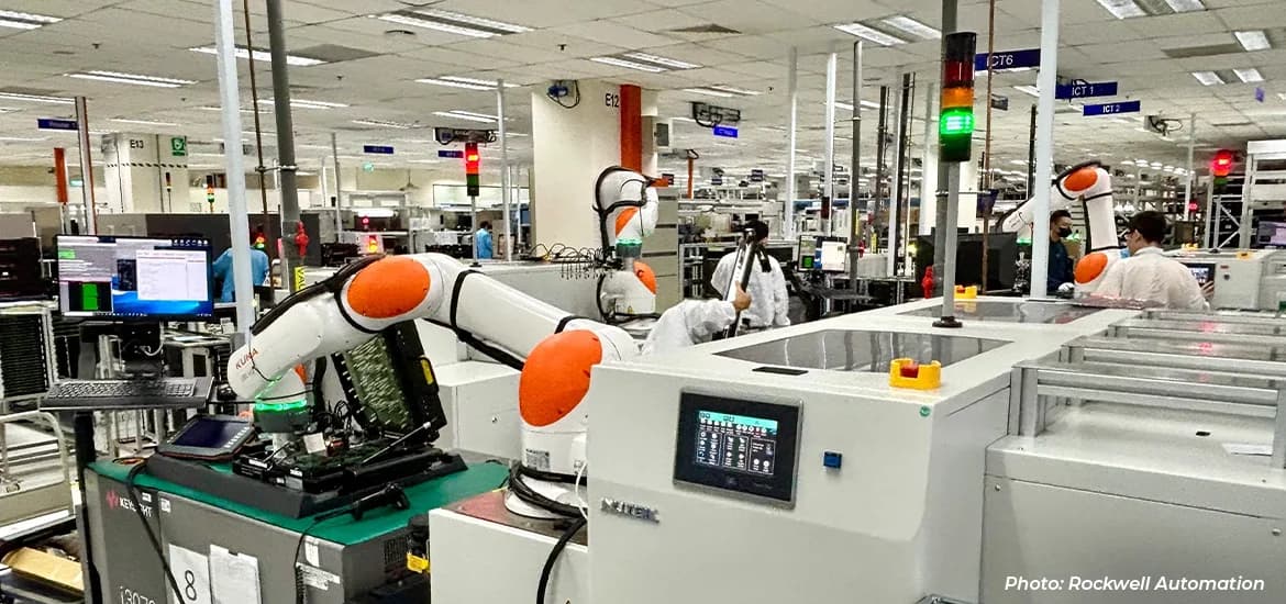 Robotic arms operating automated equipment inside a manufacturing facility.