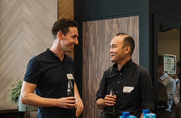 Two men smiling and chatting at a casual gathering