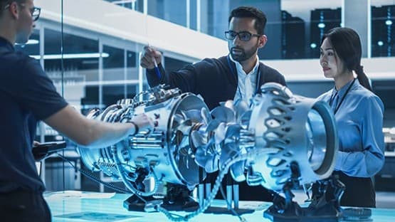 Researchers examining a mechanical component in a lab.