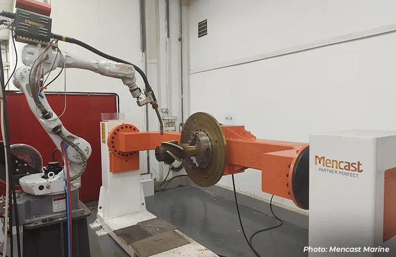 A robotic arm operates on a mounted mechanical component during automated testing inside an industrial facility.