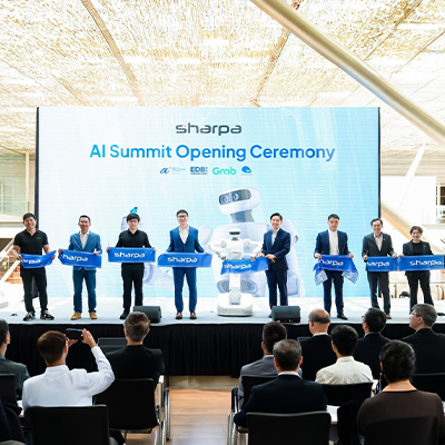Officials and industry representatives stand on stage holding ceremonial banners during the Sharpa AI Summit Opening Ceremony. A large digital backdrop displays event branding, partner logos, and a humanoid robot, while attendees watch from the audience.