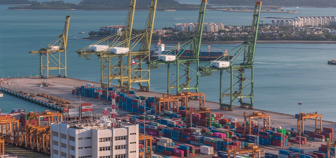 Aerial view of a major shipping port with cranes and stacked containers, symbolizing global trade, logistics, and economic connectivity.