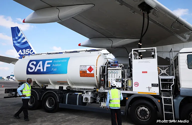 Ground crew refueling an aircraft with a tanker labeled “SAF Sustainable Aviation Fuel” on the airport tarmac.
