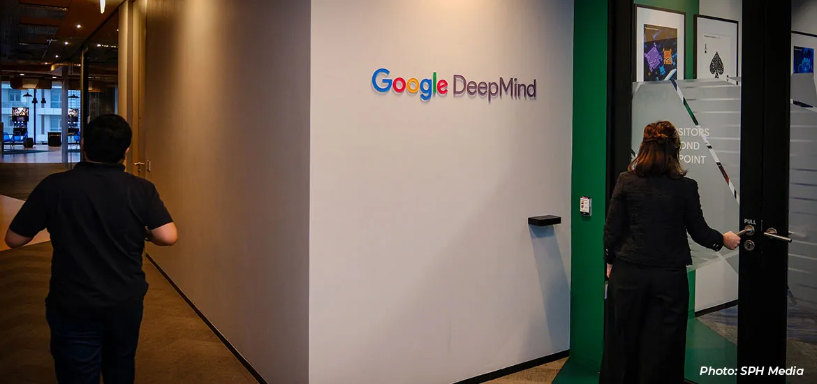 Entrance to a Google DeepMind office with people walking in a hallway.