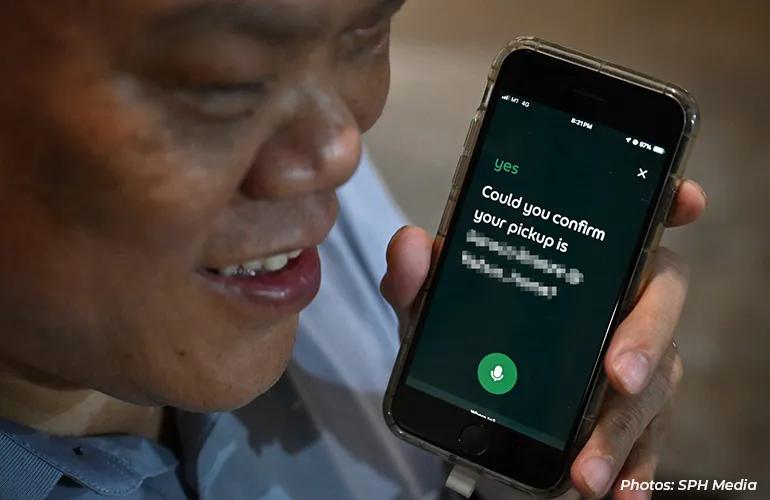 Person holding a smartphone showing a voice assistant screen asking to confirm a pickup.