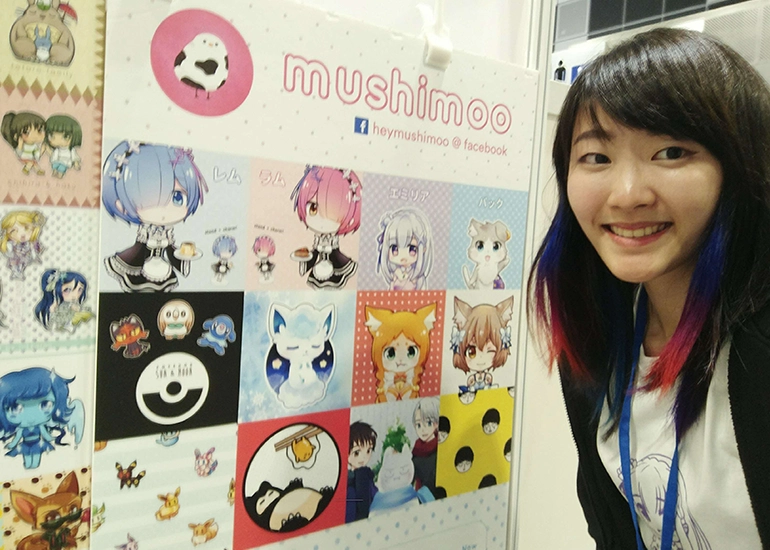 Xinni pictured alongside her merchandise at an anime festival.