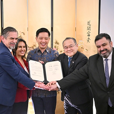 Group of business and government representatives celebrating the signing of a partnership agreement, symbolizing international collaboration and strategic cooperation.