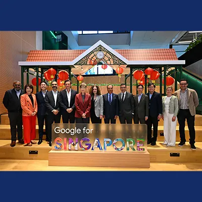 Group photo of officials and representatives standing behind a “Google for Singapore” sign with red lantern decorations in the background.