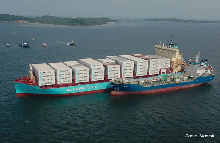 Maersk container ship refueling at sea alongside a supply vessel, showcasing sustainable maritime operations and low-emission shipping solutions.