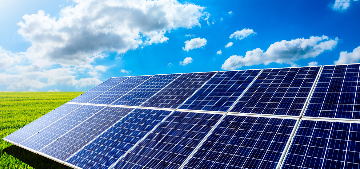 Solar panels installed in an open field under a bright blue sky, generating renewable energy through sustainable solar power technology.