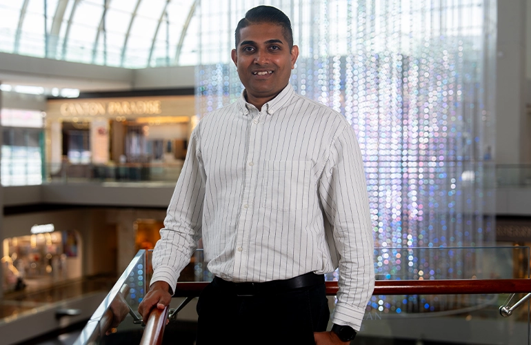 Kalidasan Raman profile image with Marina Bay Sands mall at the background.