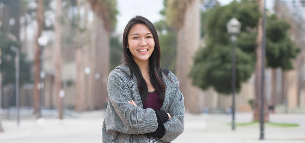 Rachel Lim and a colleague engaged in a focused discussion over a laptop in a warmly lit coworking space.