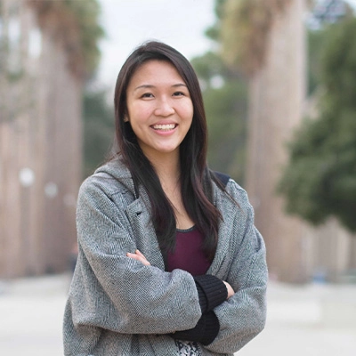 Rachel Lim and a colleague engaged in a focused discussion over a laptop in a warmly lit coworking space.