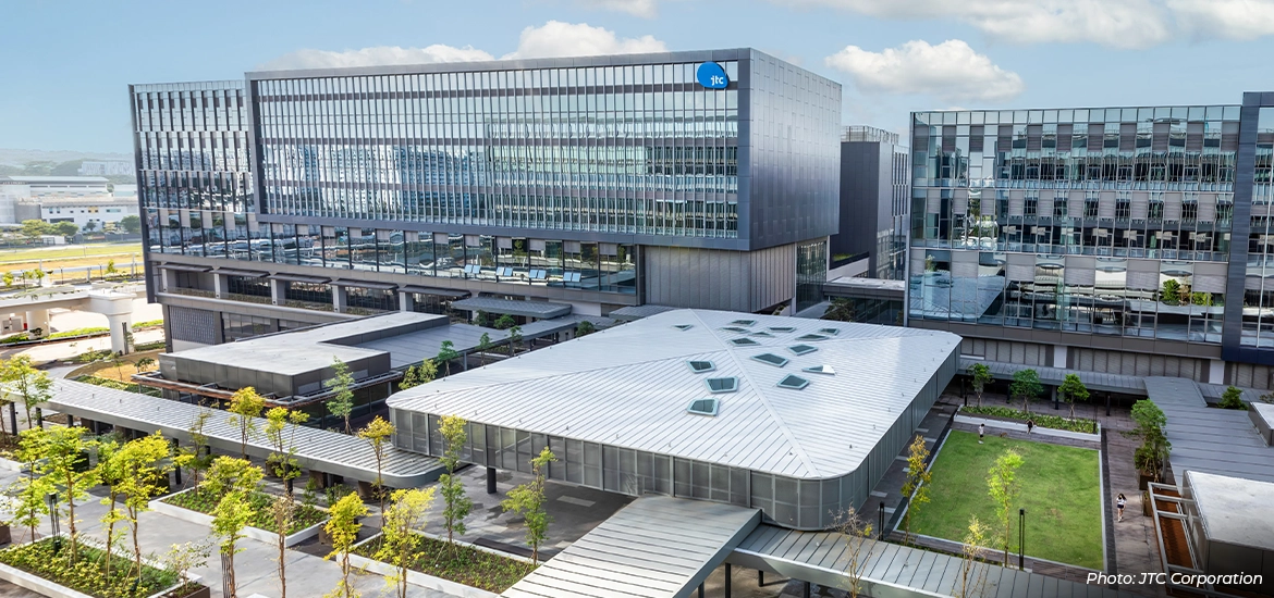Modern research and innovation campus in Singapore with glass-fronted office buildings, landscaped walkways, and green spaces, highlighting advanced infrastructure for science, technology, and R&D (photo by JTC Corporation).