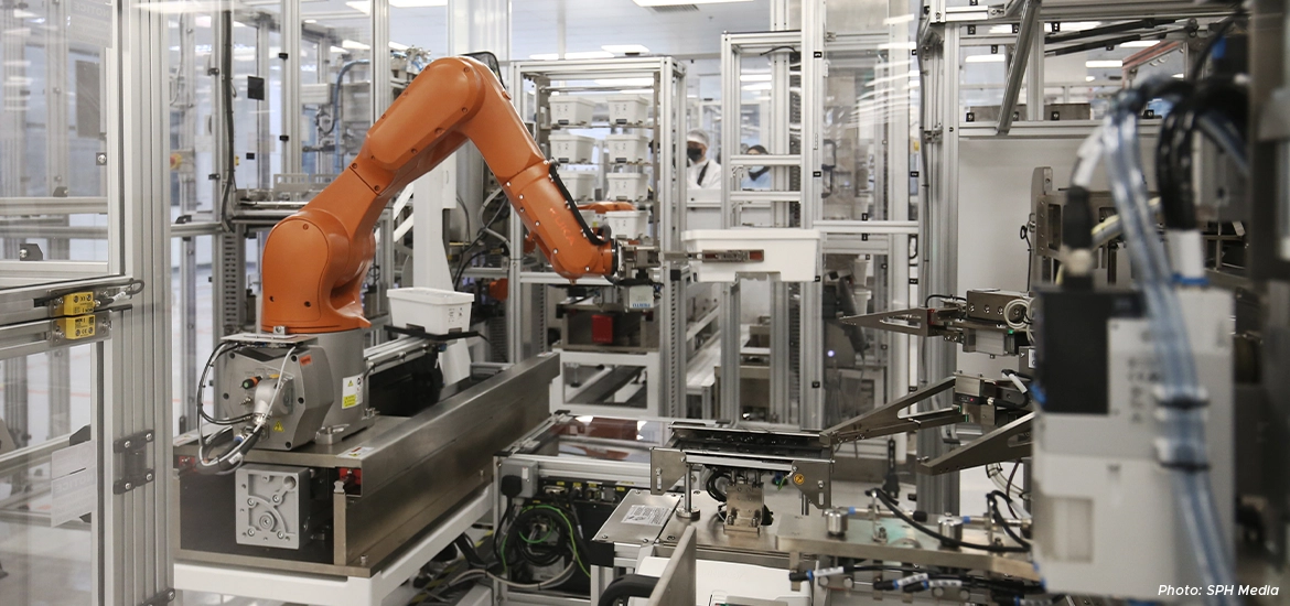 Industrial robotic arm operating autonomously in a high-tech automated manufacturing facility with intricate machinery and cleanroom environment.