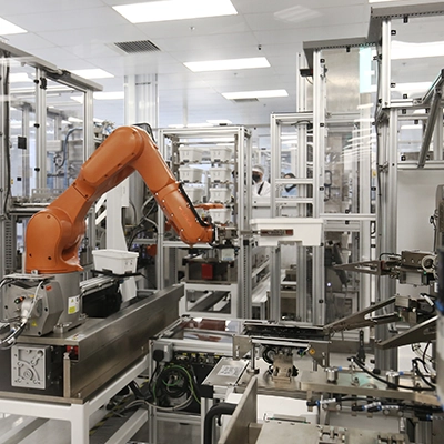 Industrial robotic arm operating autonomously in a high-tech automated manufacturing facility with intricate machinery and cleanroom environment.