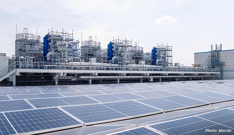 Rooftop solar panels at Micron’s semiconductor facility in Singapore with advanced industrial equipment and fabrication infrastructure in the background.