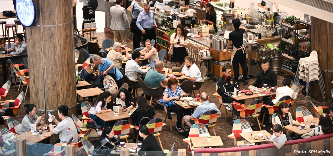 Busy café scene with diners enjoying food and drinks in a vibrant indoor dining area.