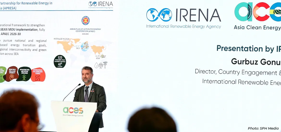 IRENA Director delivers a keynote presentation at the Asia Clean Energy Summit, standing at a podium with IRENA and ACES logos displayed on a large screen highlighting renewable energy partnerships and regional cooperation.