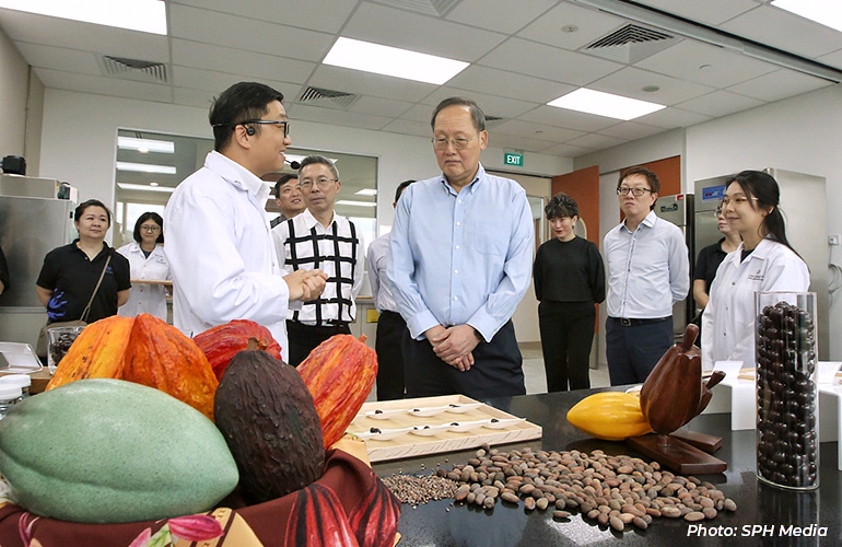 Manpower Minister Tan See Leng (centre) at Barry Callebaut's global innovation hub in Geneo, with the chocolate manufacturer's head of research and development, Mr Liu Yeting (left), and CapitaLand Development CEO Jonathan Yap (second from left).
