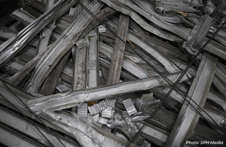 Pile of bundled scrap metal strips ready for recycling at an industrial facility.