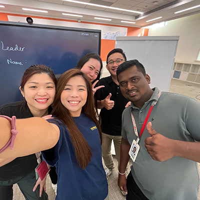 Group selfie of Huawei employees participating in a team-building or workplace training session, smiling and posing together in a collaborative office environment.