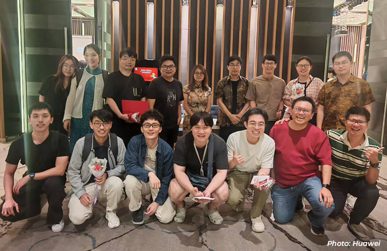 Group photo of Huawei employees gathered at a company event, smiling and posing together in an indoor venue, reflecting team camaraderie and workplace culture.