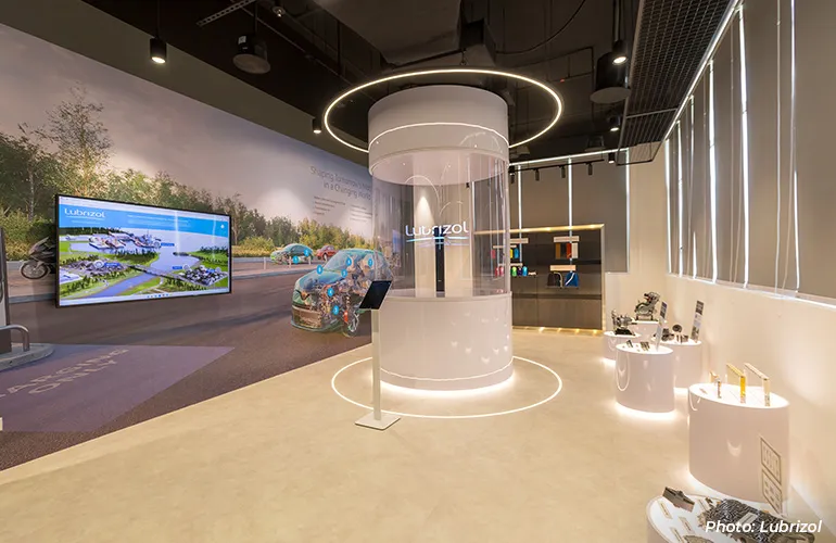 Modern innovation showroom with a central Lubrizol display, digital screens, and product exhibits.