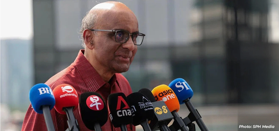 Man speaking to reporters at a media briefing with multiple microphones in front of him.