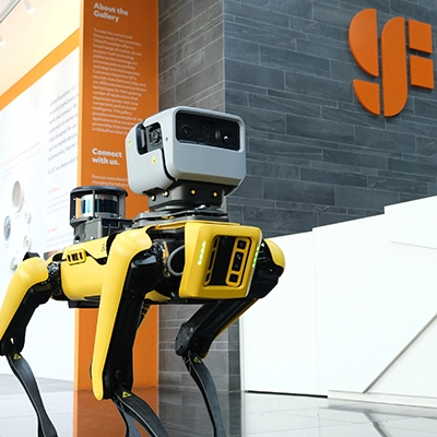 Yellow robotic dog displayed inside a technology gallery.