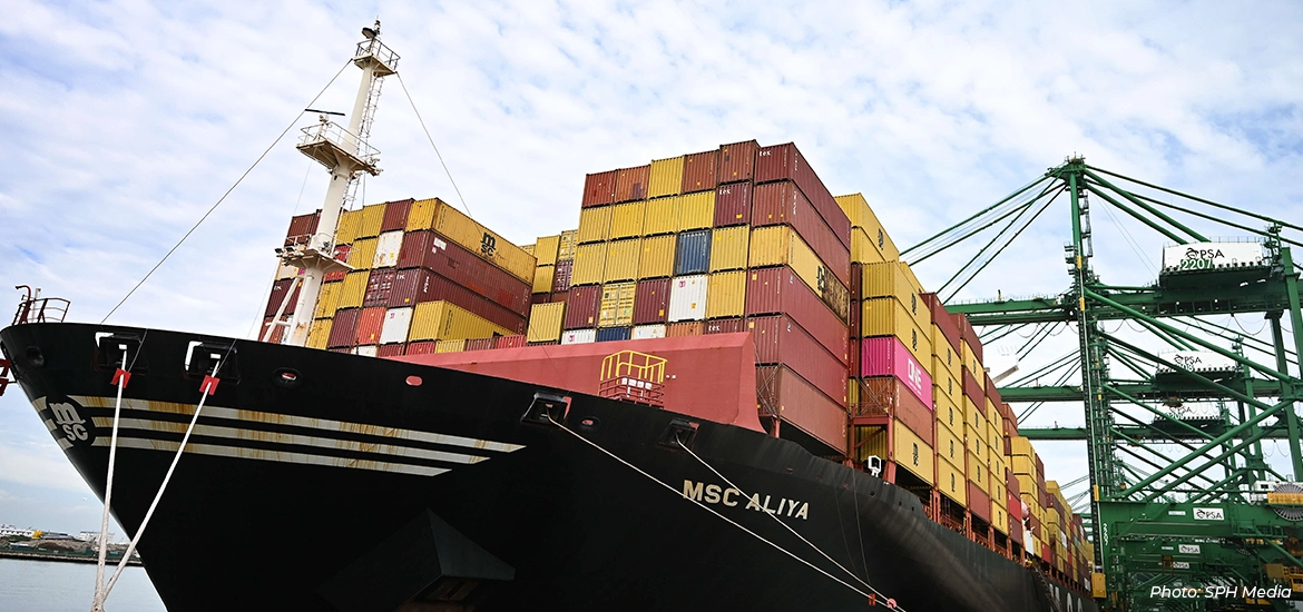 Large container ship MSC Aliya docked at a Singapore port, stacked with multicoloured shipping containers as gantry cranes load and unload cargo, highlighting Singapore’s role as a global maritime and logistics hub.