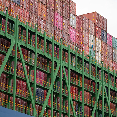 Close-up view of stacked shipping containers arranged on a large cargo vessel, highlighting global trade and maritime logistics operations.