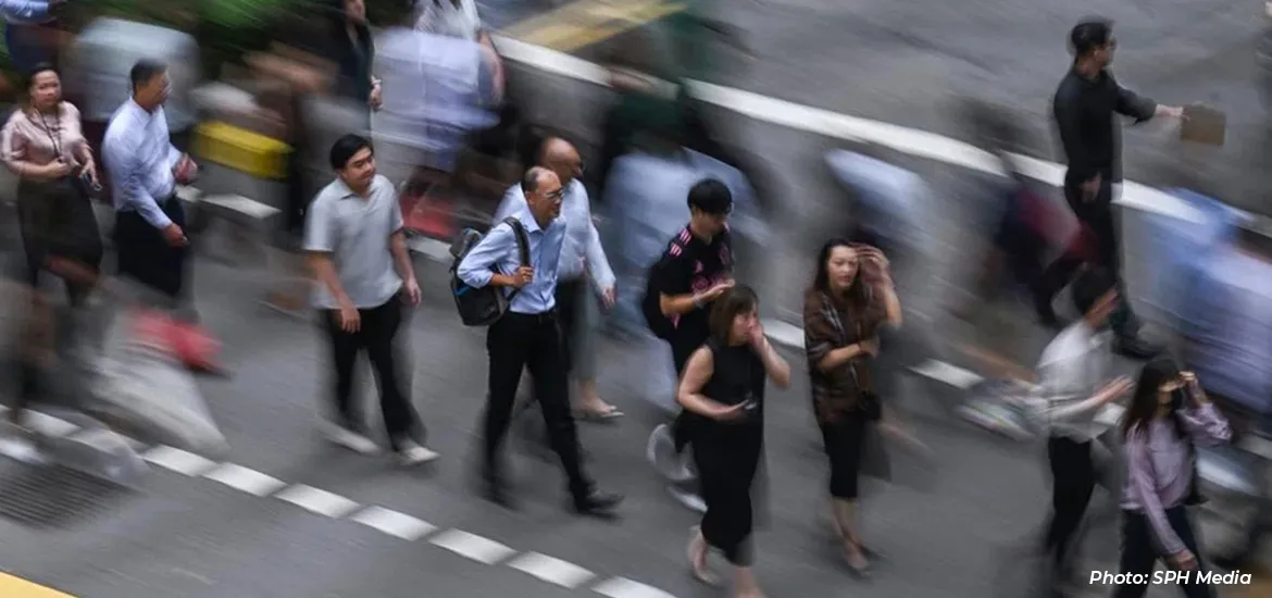 Blurred motion view of people walking across a busy street crossing in a city.