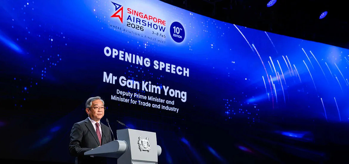 Man delivering an opening speech at the Singapore Airshow 2026, standing at a podium with a large event screen backdrop.