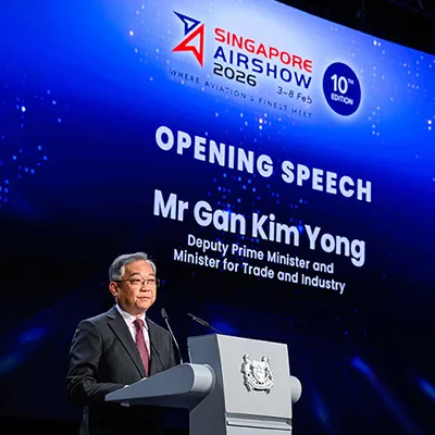Man delivering an opening speech at the Singapore Airshow 2026, standing at a podium with a large event screen backdrop.