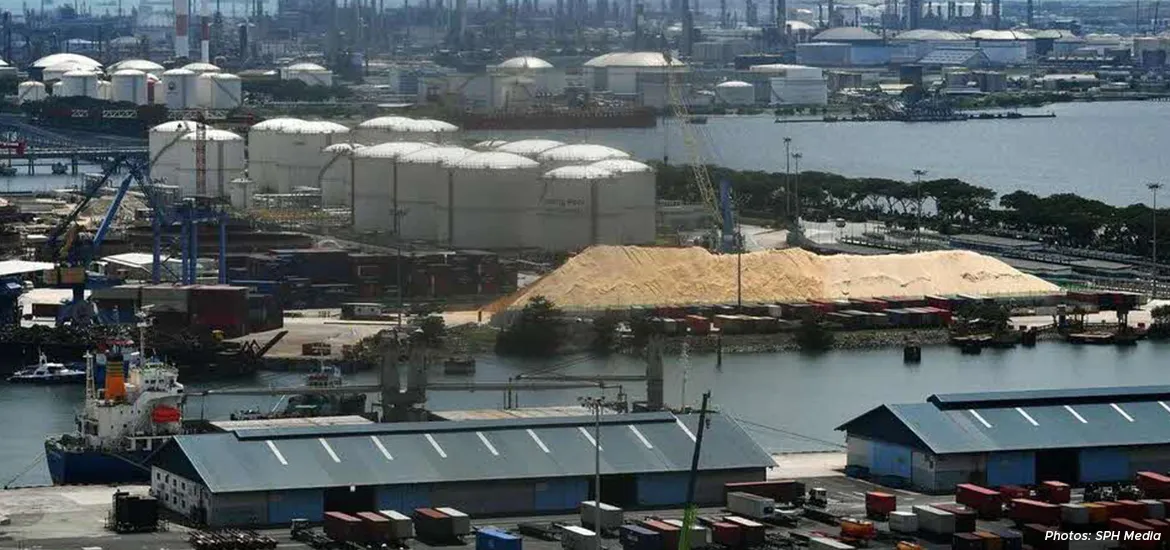Singapore industrial port with storage tanks, cargo ships, and raw material stockpiles, showcasing the country’s petrochemical and logistics hub.”