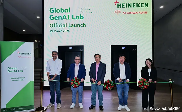 Executives and partners pose at the ribbon-cutting ceremony for Heineken’s Global GenAI Lab official launch in Singapore on 19 March 2025, standing in front of a branded digital backdrop with Heineken and AI Singapore logos.