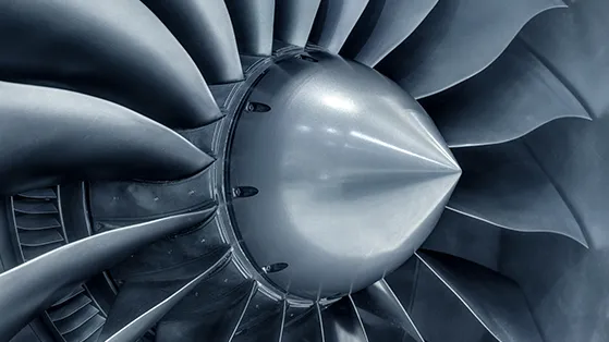 Close-up of aircraft engine turbine blades, representing precision aerospace manufacturing.