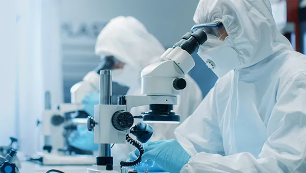 Scientist working with microscope in modern lab, representing a strong talent pipeline.