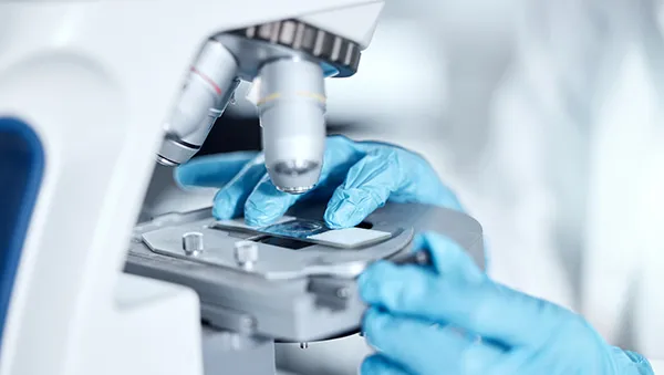 Engineer using tablet with digital interface in a factory, representing AI and advanced manufacturing.