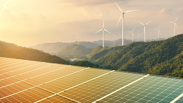 Solar panels and wind turbines on hills, symbolizing carbon capture and green hydrogen initiatives.