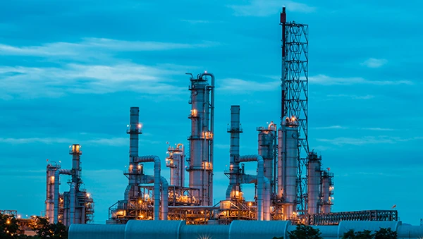 Illuminated industrial plant at dusk, symbolizing Singapore as a global business hub.