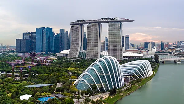 A scenic view of Singapore’s Marina Bay area showcasing iconic landmarks like Marina Bay Sands and the Flower Dome, symbolizing the city's transformation into a global hub for innovation and renewable energy.