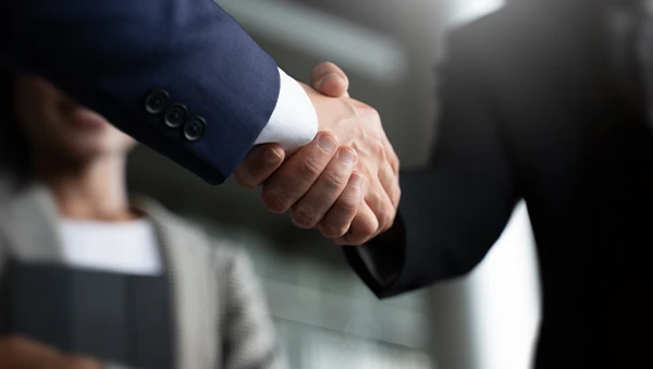 Close-up of a handshake between two business professionals, symbolizing public-private partnerships and collaborative agreements.